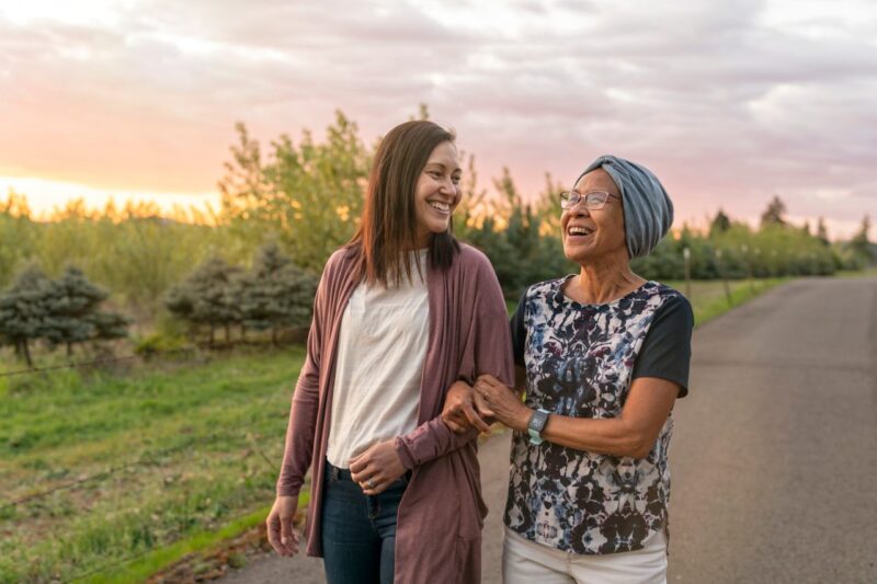 Two smiling women enjoy a walk outdoors